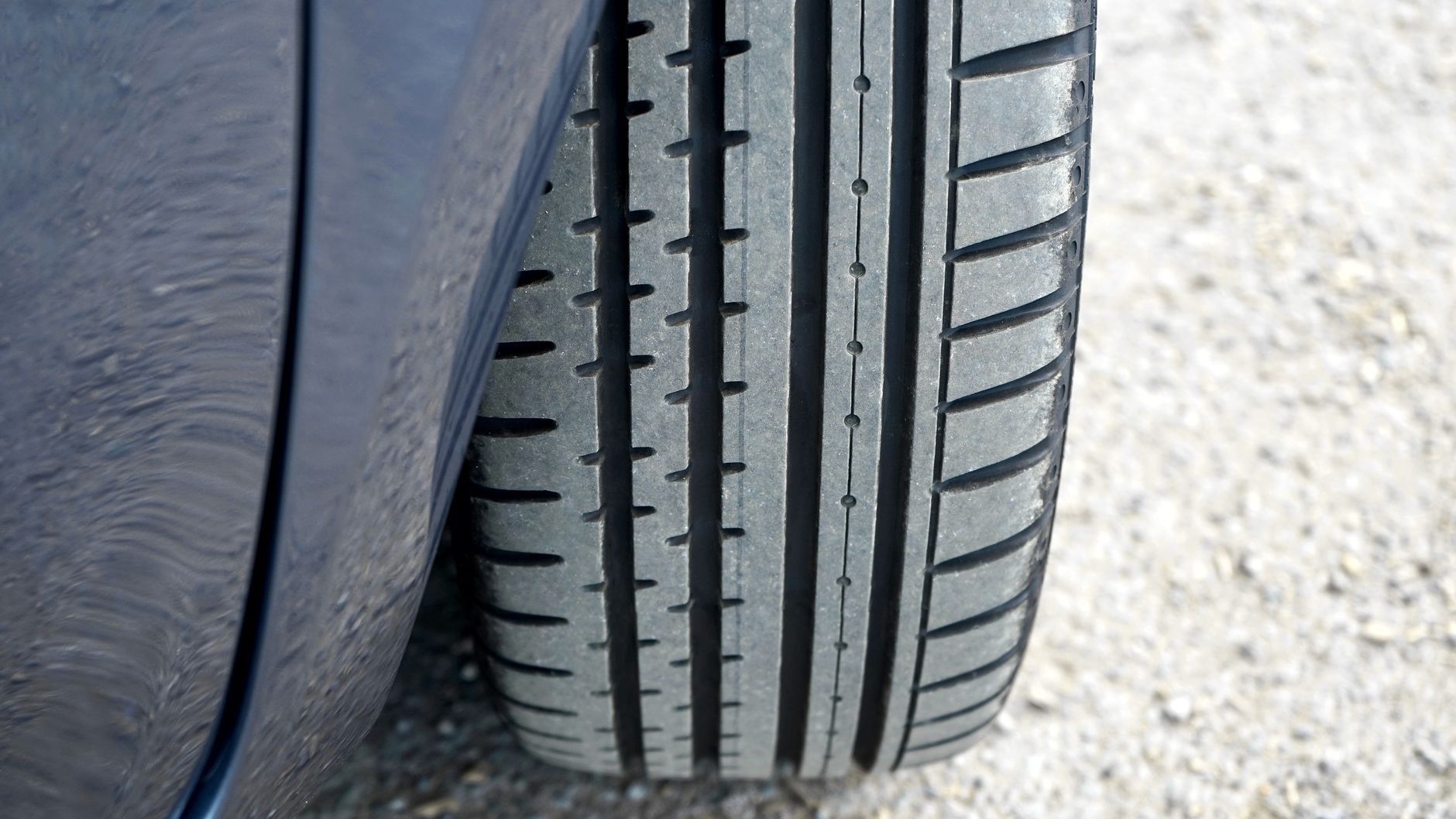 Close-up of a car tyre showing its tread pattern and grooves