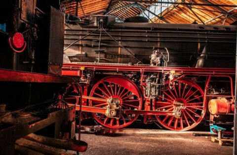 Restored steam locomotive wheels and boiler inside a workshop